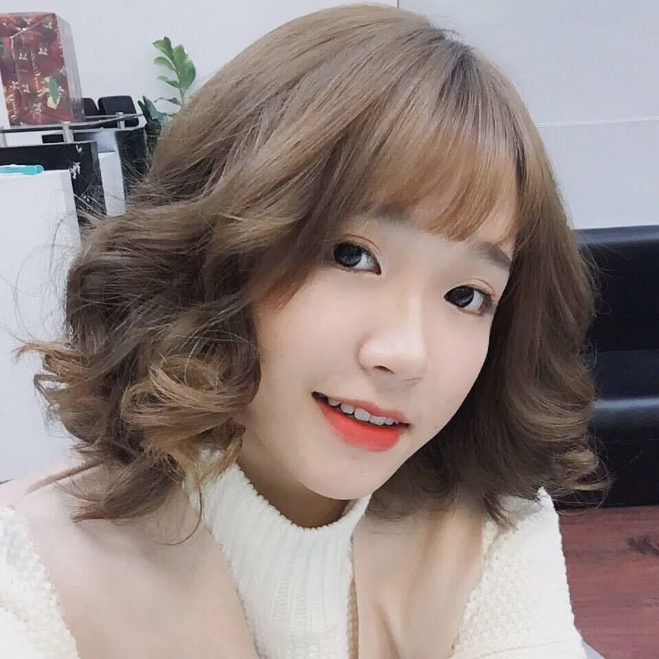 Cô gái với mái tóc bob xoăn ngắn màu nâu sáng