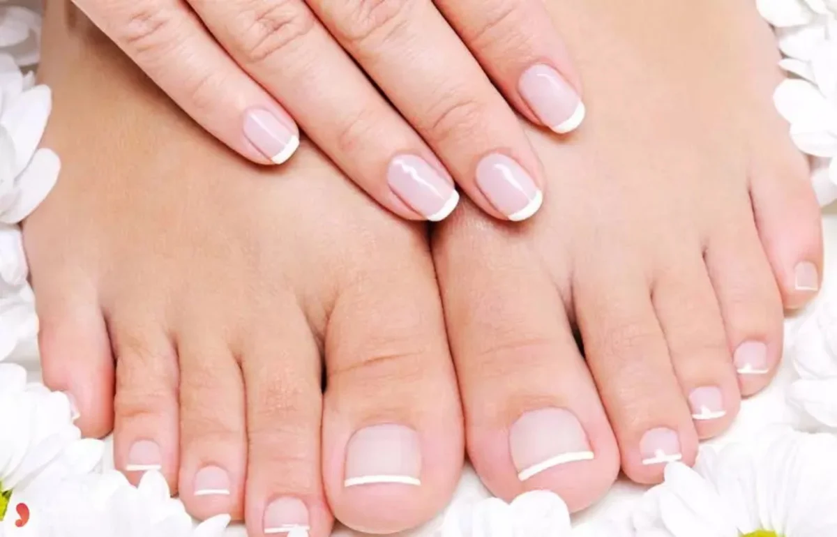 Móng chân đẹp sơn hồng nhạt kiểu Pháp cùng bàn tay được chăm sóc trên nền hoa trắng